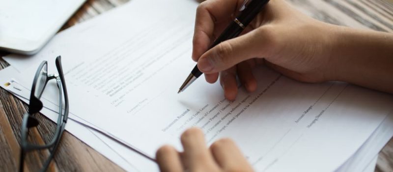 businessman-examining-papers-table (1)